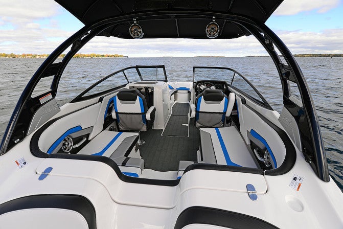 The main cockpit features a wrap-around rear bench seat with transom pass-through, complemented by twin buckets on swivel bases.